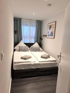 a bed in a small room with a window at Sky & Sand SPO Nordsee by Nature I Boxspringbett, Terrasse, Zentral, Nah am Deich in Ording
