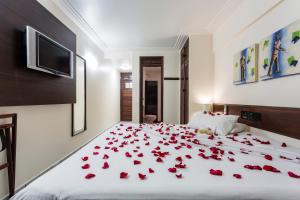 um quarto com rosas deitadas numa cama em Pizzato Praia Hotel em Natal