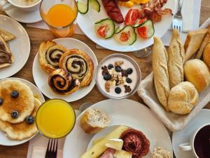 una mesa cubierta con platos de comida y bebida para el desayuno en Holdvirág Hotel en Sárvár