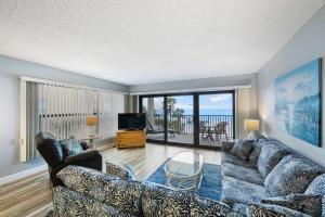 a living room with a couch and a table and a television at 201 Sandy Shores Condos in St Pete Beach