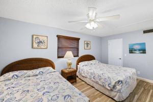 sypialnia z 2 łóżkami i wentylatorem sufitowym w obiekcie 201 Sandy Shores Condos w St Pete Beach