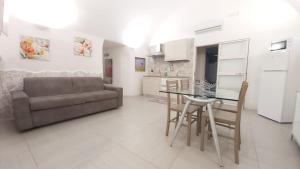 a living room with a couch and a table and chairs at Casa vacanze G&G in Brindisi
