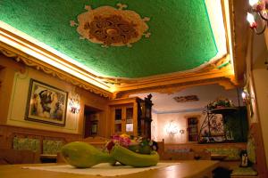 una camera con tavolo e soffitto verde di Digonera Historic Hotel B&B a Rocca Pietore