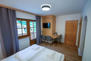 1 dormitorio con 1 cama y 1 mesa con sillas en Sporthotel Dachstein West en Annaberg im Lammertal