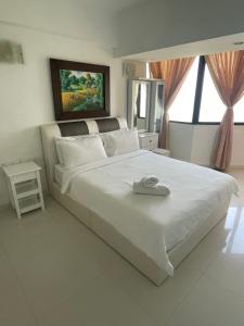 a bedroom with a large white bed with a large window at The Ferringhi Sea View at Sri Sayang in Batu Ferringhi