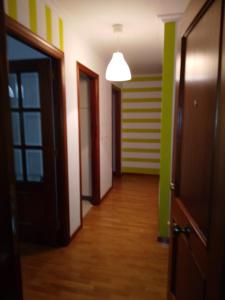 einen leeren Flur mit grünen und gelben Wänden und Türen in der Unterkunft A Las faldas del Tecla in A Guarda