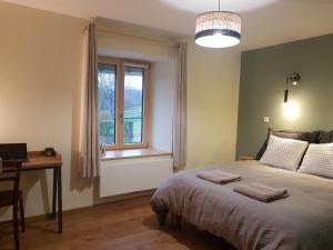 Schlafzimmer mit einem Bett, einem Schreibtisch und einem Fenster in der Unterkunft Le Cottage in Sorans-lès-Breurey
