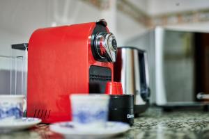 a red coffee maker sitting on a counter with two cups at YourPlace Rabat Agdal 1 - Cozy Residence in Rabat