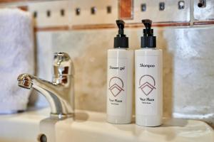 two bottles of sunscreen sitting on a bathroom sink at YourPlace Rabat Agdal 1 - Cozy Residence in Rabat