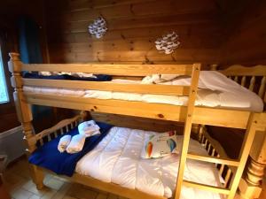 ラ・ブレスにあるLE FISHING LODGE Chalet en bois avec bain nordiqueの二段ベッド2組(タオル付)が備わる木造の部屋です。