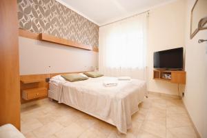 a bedroom with a bed and a flat screen tv at Victus Apartamenty, Apartament Daria Luiza in Sopot