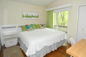 a bedroom with a bed and a table and a window at Autumn Wings - Propane Grill, Wifi, Kid Friendly, King Bed, Games, Screen Porch, Pool Access, Hiking in Berkeley Springs +48 photos