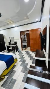 een slaapkamer met een bed en een tv op een jacht bij أجنحة بلو روز الفندقية in Najran