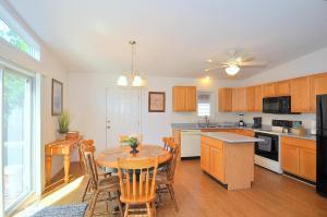 a kitchen with a wooden table and a dining room at Cacapon Connected - Wifi, Fire Pit, Game Room, King Bed, Deck, Grill, Fireplace, Pet Friendly, Garage for mountain bike storage in Morton Grove