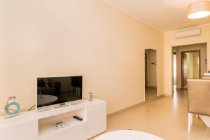 una sala de estar con TV en un centro de entretenimiento blanco en NEW !! Two Bedroom Cabanas Tavira - Banda Musical ORANGE, en Tavira