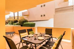 a table and chairs on the balcony of a building at NEW !! Two Bedroom Cabanas Tavira - Banda Musical ORANGE in Tavira