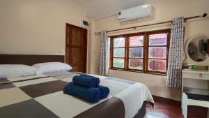 Un dormitorio con una cama con almohadas azules. en Common Camping KhaoYai en Mu Si
