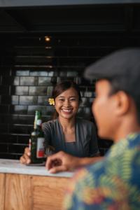une femme assise à une table avec une bouteille de bière dans l'établissement East Bali Volcano View Resort & Spa - Adults Only Area, à Karangasem