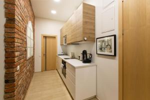 a kitchen with white counters and a brick wall at L studio in Kaunas