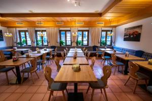 a restaurant with wooden tables and chairs and windows at Sporthotel Dachstein West in Annaberg im Lammertal