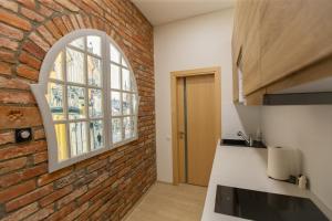 a kitchen with a brick wall and an arch window at L studio in Kaunas