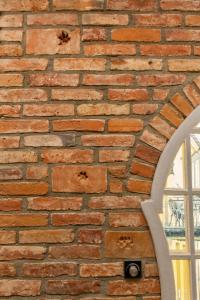 a brick wall with a mirror and a window at L studio in Kaunas