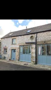a brick building with blue doors on a street at Barn Cottage in Youlgreave