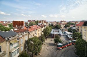 een stad met een bus op een straat met gebouwen bij DOT Sofia Apart Hotel in Sofia
