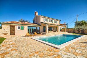 a villa with a swimming pool in front of a house at Villa Fumeti in Barban