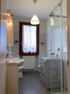 y baño con bañera, lavamanos y ducha. en Casa Vacanze PETIT GARDA, en Raffa