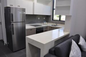 a kitchen with a stainless steel refrigerator and a counter at The Corner, Luxury One-Bedroom in Ras al Khaimah