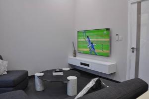 salon z telewizorem z płaskim ekranem na ścianie w obiekcie The Corner, Luxury One-Bedroom w mieście Ras al-Chajma