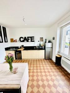 a room with a kitchen with a table and a refrigerator at La dolce Vita/maison/5km plages in Saint-Brieuc