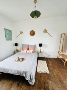 a bedroom with a bed with white sheets and wooden floors at La dolce Vita/maison/5km plages in Saint-Brieuc