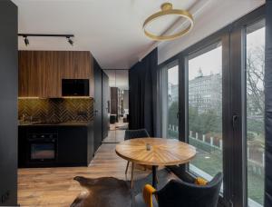 a kitchen and living room with a table and chairs at Cracow Luxury Apartment #11 in Krakow