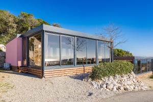 a house with large glass windows on the side of it at Kasthouse Luxury Nature Getaway in Mali Lošinj