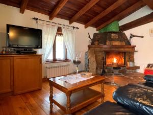 a living room with a fireplace and a tv at Hotel Peruskenea in Jaunsaras