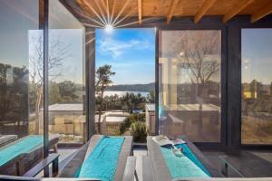 a house with two swimming pools and glass walls at Kasthouse Luxury Nature Getaway in Mali Lošinj