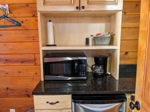 um balcão de cozinha com um micro-ondas e comodidades para preparar café em Bryce Canyon Villas em Cannonville