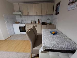 a kitchen with a table with a bowl of fruit on it at Guesthouse Jelena in Višegrad