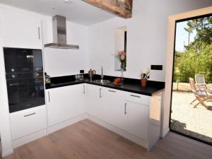 a kitchen with white cabinets and a black counter top at Hares Barn in Trowbridge