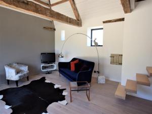 a living room with a blue couch and a table at Hares Barn in Trowbridge