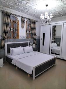 a bedroom with a large bed and a chandelier at La rose des sables 