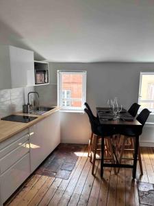 uma cozinha com uma mesa e uma mesa e cadeiras em Appartement - Carmes em Toulouse