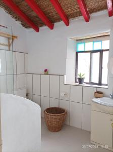 Baño blanco con lavabo y aseo en Casa rural con piscina, en Torre de Benagalbón