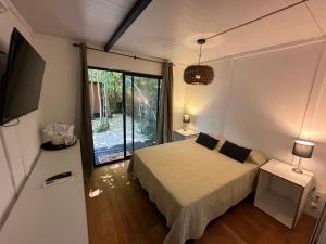 a bedroom with a bed and a large window at Posada Guasu in Punta del Este