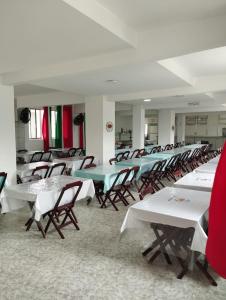 una fila de mesas y sillas en una habitación en Resort Saúde Premium, en Peruíbe