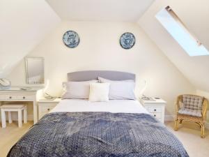 a bedroom with a bed and two tables and a mirror at Pears Grove - Southbourne in Emsworth