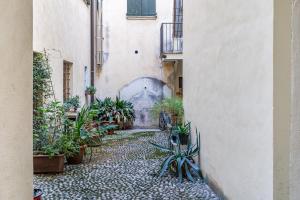 cortile con piante in vaso in un vicolo di Casa San Faustino - Brescia CityCenter - by HOST4U a Brescia