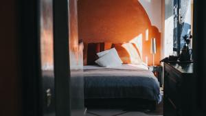 um quarto com uma cama com uma cabeceira laranja em Riad Dar El Masa em Marrakech